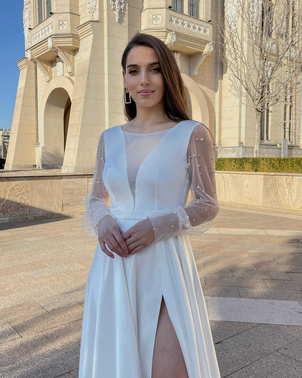 Rochie de mireasa lungă cu mâneci din tulle împodobite cu perle și decolteu în V, design elegant.