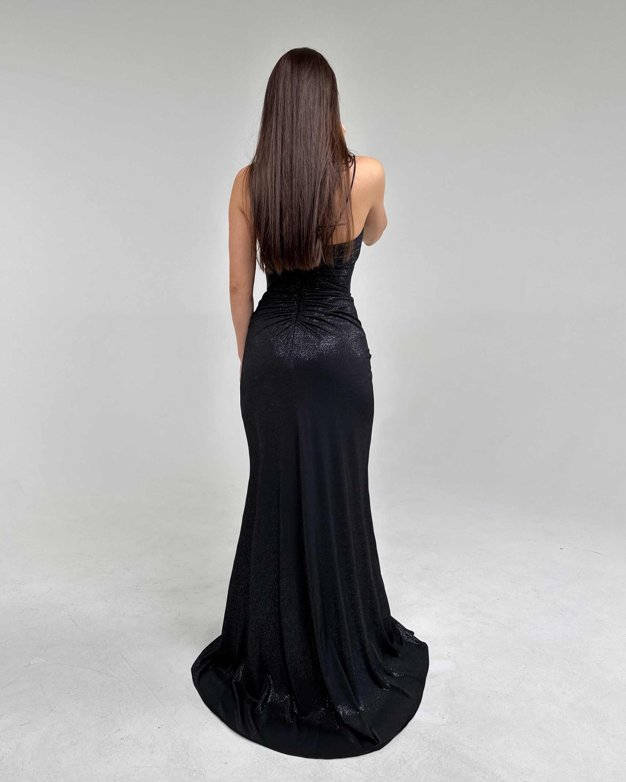 Rochie neagră elegantă cu bretele și slit, decolteu adânc și material elastic, vedere din spate.