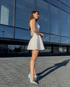 Rochie alba elegantă scurtă pentru evenimente speciale, design feminin cu decolteu delicat și fermoar discret.