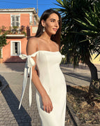 Rochie alba elegantă cu slit lateral, bretele evazate, design sofisticat pentru ocazii speciale.