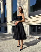 Rochie cu corset neagră cu corset drapat și bretele subțiri, design elegant.