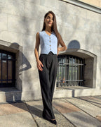 Vesta damă albastră cu croi cambrat, din stofă elastică, decolteu în V, nasturi și buzunare ascunse.