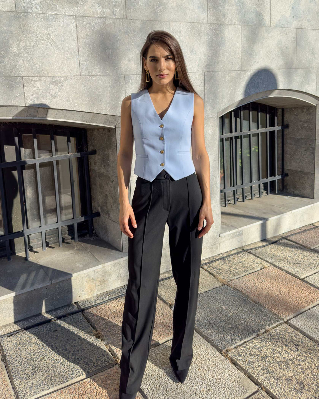 Vesta damă albastră cu croi cambrat, nasturi și decolteu în V.