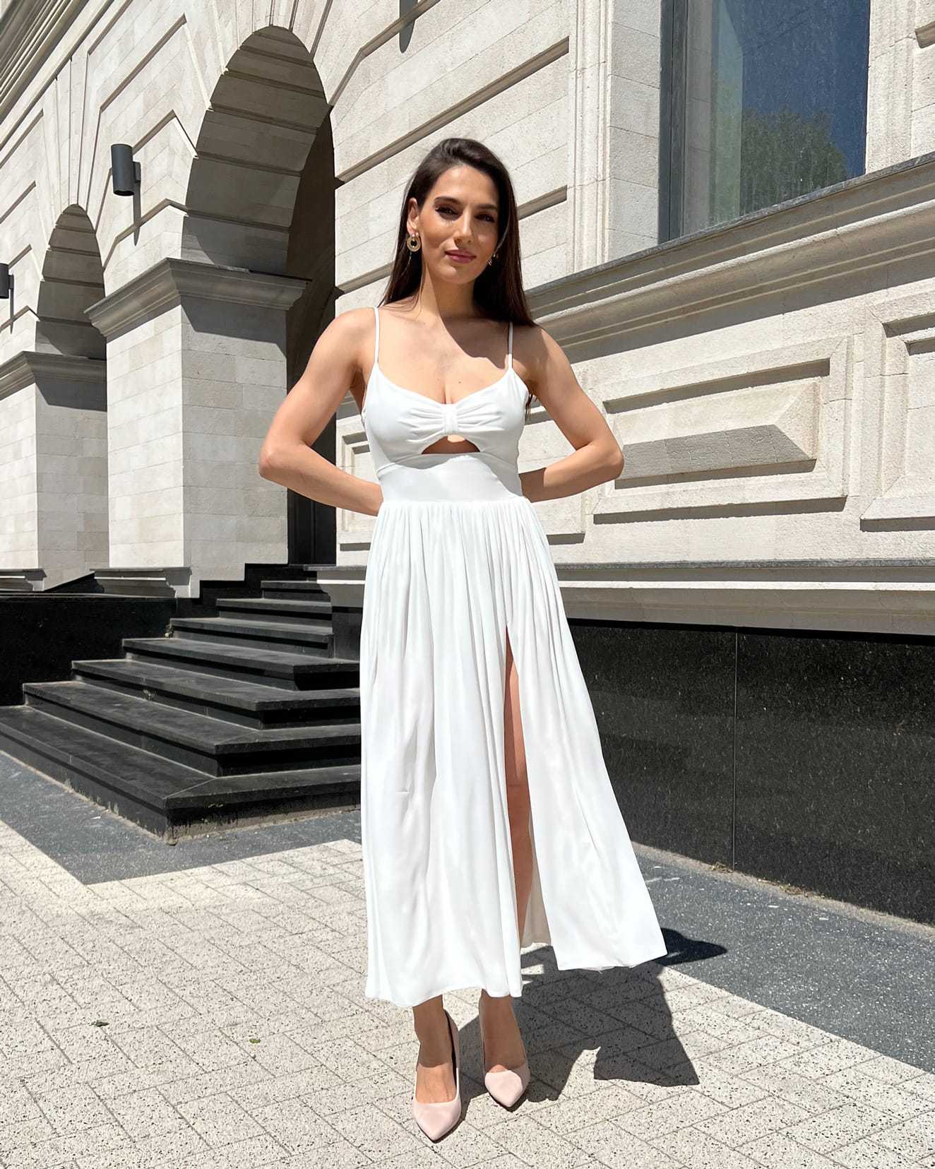 Rochie alba elegantă midi cu slit și bretele, accesorizată cu centură, fermoar la spate.