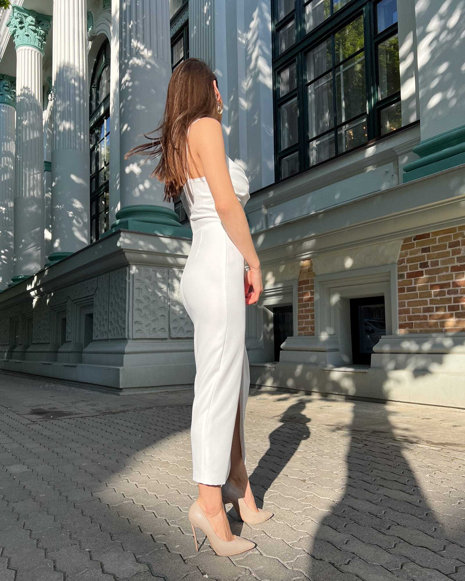 Rochie alba elegantă cu bretele și slit, lungime 108 cm, material crep elastic, potrivită pentru evenimente speciale.