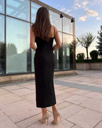 Rochie eleganta neagră de seară cu tăietură pe mijloc, croială ajustată, fermoar la spate, căptușeală interioară, model purtând mărimea XS.